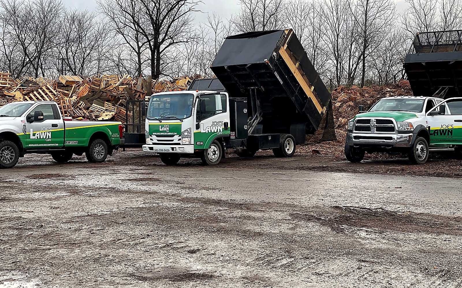 Joe's Lawn Care dump trucks and outdoor project equipment